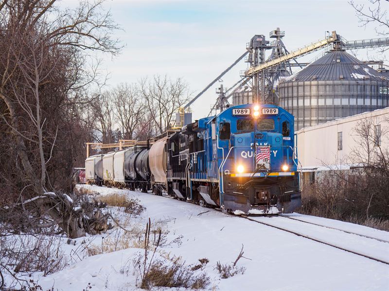 Finger Lakes Railway locomotive 1989 passing grain elevators in winter