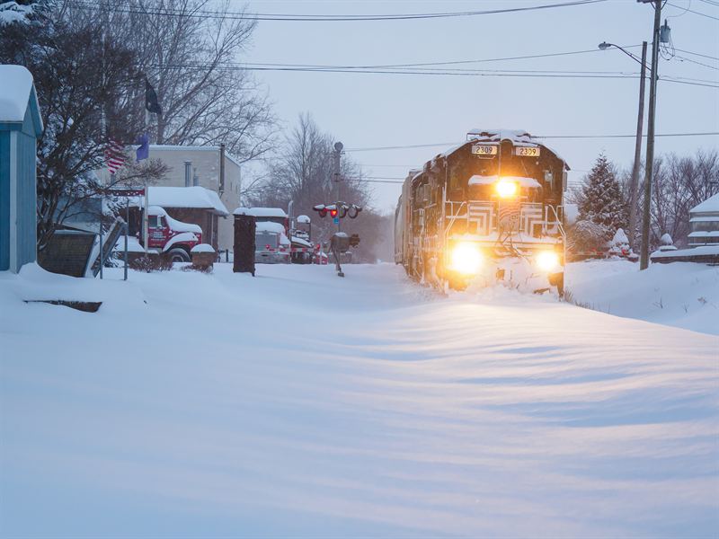 Finger Lakes Railway locomotive plowing through deep snow at a crossing